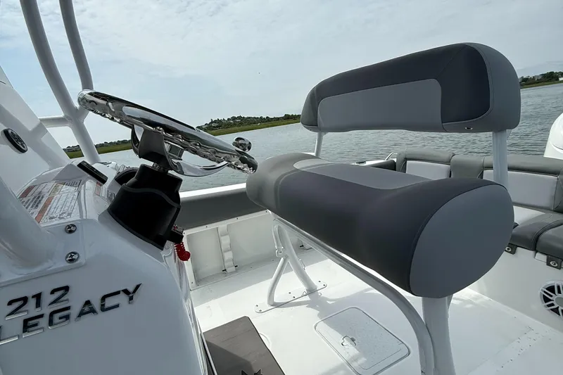 Slide: The Image of 2025 NauticStar 212 Legacy boat interior with steering wheel and seating. - 16