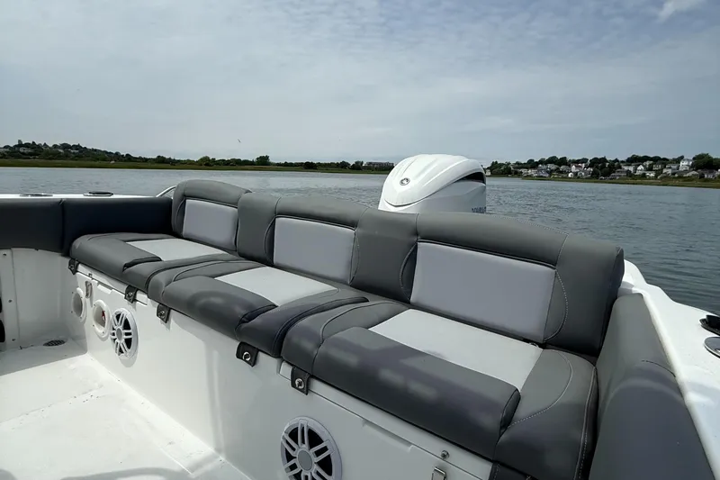 Slide: The Image of 2025 NauticStar 212 Legacy boat with cushioned seating, on a calm water backdrop. - 17