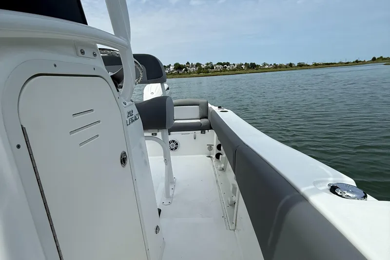Slide: The Image of 2025 NauticStar 212 Legacy boat interior with seating, on calm water. - 18
