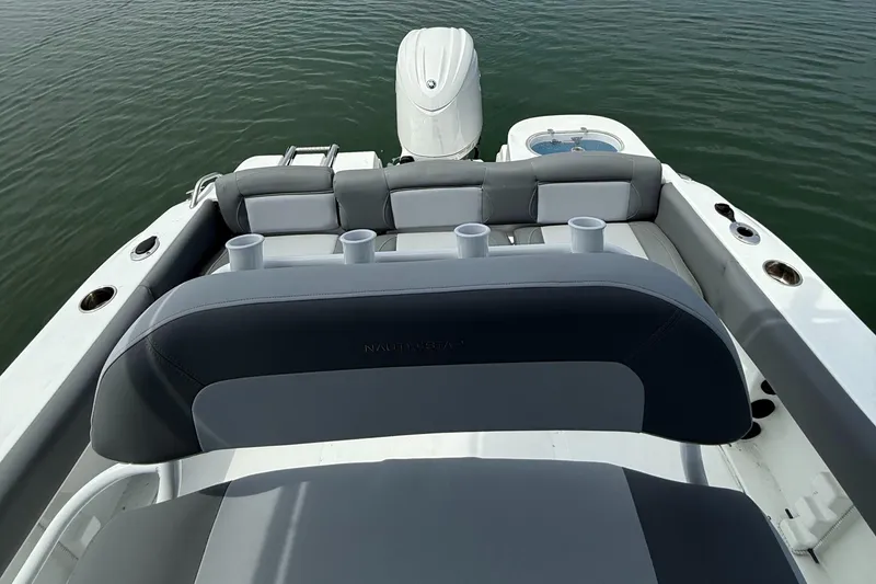 Slide: The Image of 2025 NauticStar 212 Legacy boat with seating and outboard motor on calm water. - 20