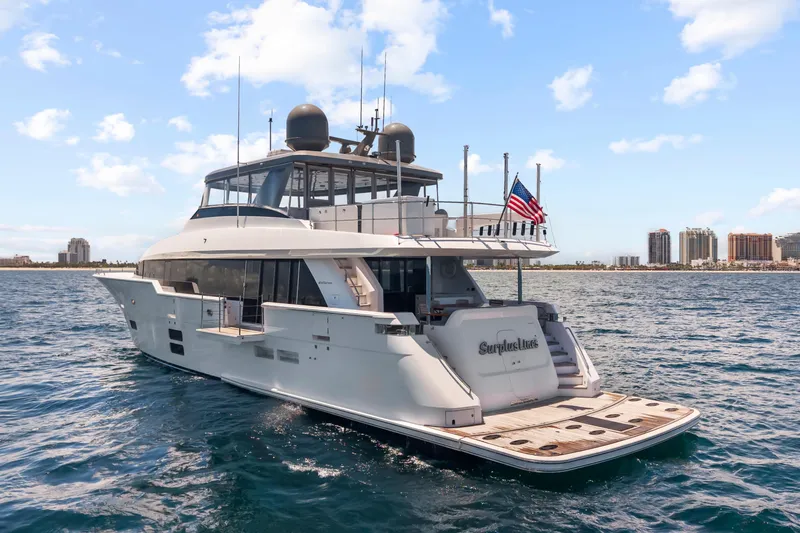 Slide: The Image of 2019 Hatteras M90 Panacera yacht on open water, city skyline in background. - 1