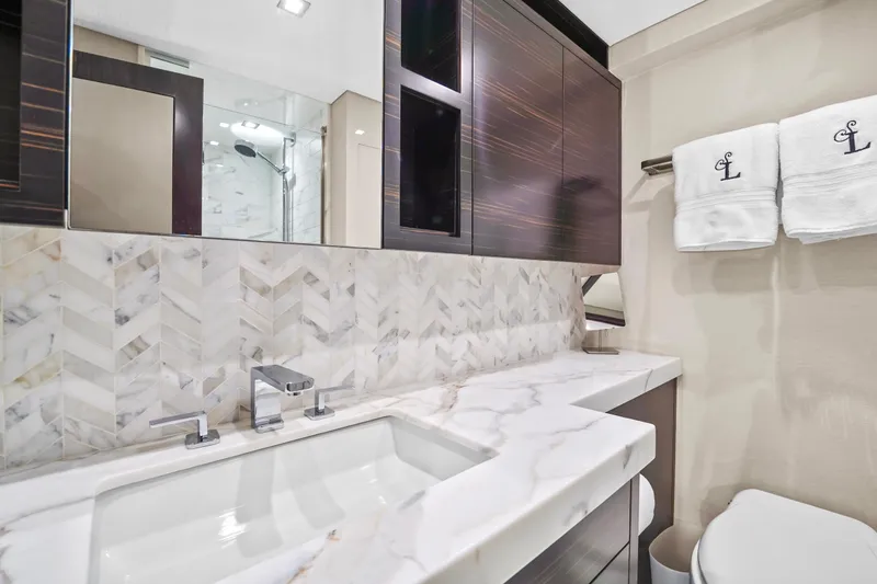 Slide: The Image of Luxurious bathroom in 2019 Hatteras M90 Panacera yacht with marble countertop and elegant fixtures. - 34