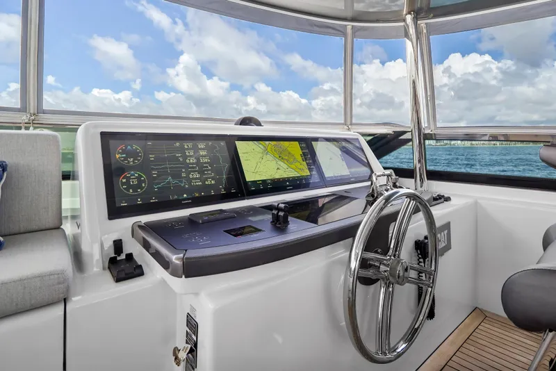 Slide: The Image of Helm of 2019 Hatteras M90 Panacera yacht with navigation screens and steering wheel. - 6