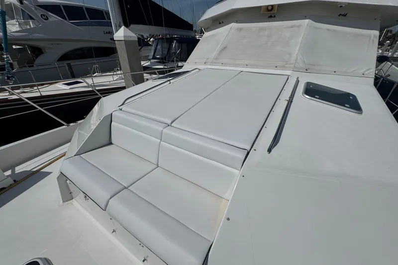 Slide: The Image of 1995 Hatteras 74 Cockpit Motor Yacht with cushioned deck seating. - 13