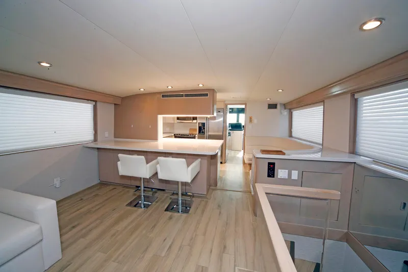 Slide: The Image of Luxurious interior of 1995 Hatteras 74 Cockpit Motor Yacht with modern kitchen and seating. - 24