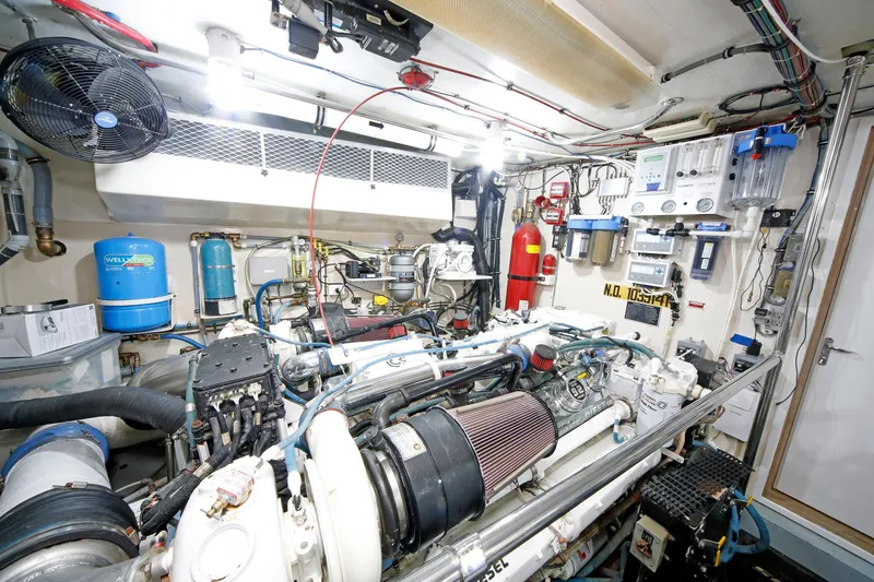 Slide: The Image of Engine room of 1995 Hatteras 74 Cockpit Motor Yacht, featuring complex machinery and equipment. - 32