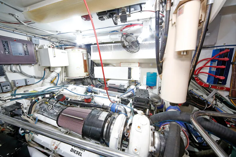 Slide: The Image of Engine room of 1995 Hatteras 74 Cockpit Motor Yacht, showcasing diesel engine and equipment. - 33