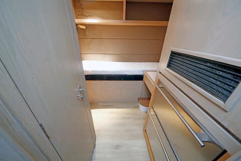 Slide: The Image of Interior cabin of 1995 Hatteras 74 Cockpit Motor Yacht, featuring wood paneling and storage. - 39