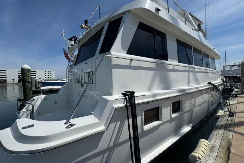 Slide: The Image of 1995 Hatteras 74 Cockpit Motor Yacht docked at marina under clear blue sky. - 6