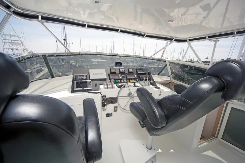 Slide: The Image of Helm of 1995 Hatteras 74 Cockpit Motor Yacht with leather seats and navigation equipment. - 62