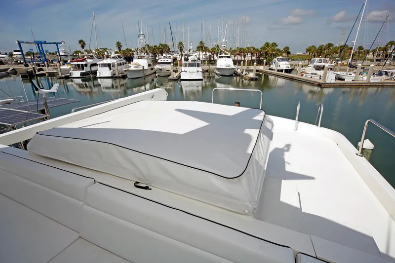 Slide: The Image of 1995 Hatteras 74 Cockpit Motor Yacht docked in a marina with other boats. - 67
