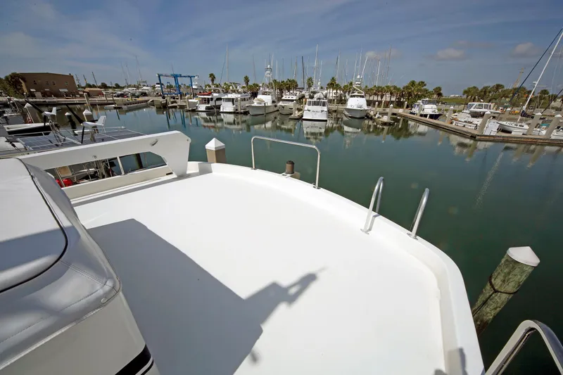 Slide: The Image of 1995 Hatteras 74 Cockpit Motor Yacht docked in a marina with calm waters. - 69