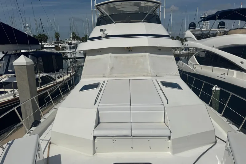 Slide: The Image of 1995 Hatteras 74 Cockpit Motor Yacht docked at marina, showcasing sleek design and spacious deck. - 7