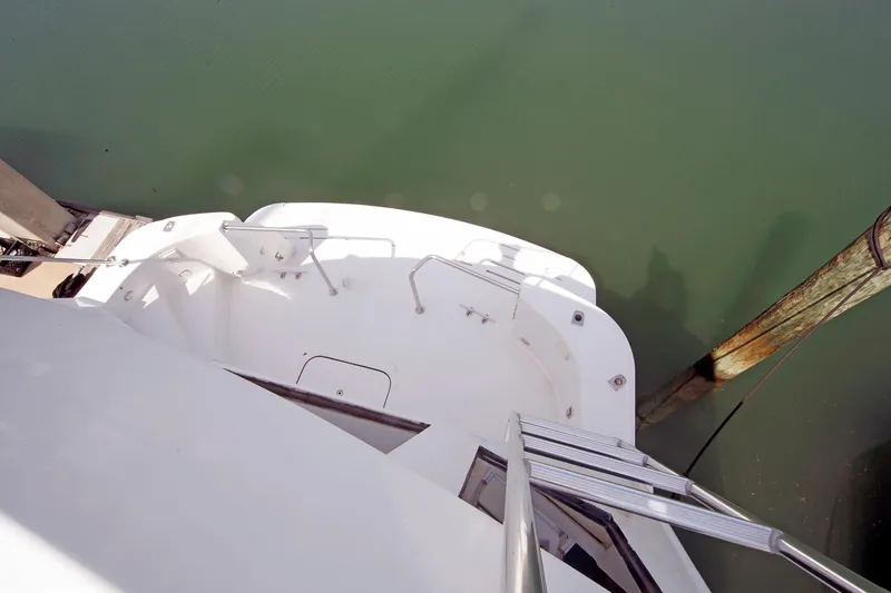 Slide: The Image of 1995 Hatteras 74 Cockpit Motor Yacht stern view with dock and water. - 70