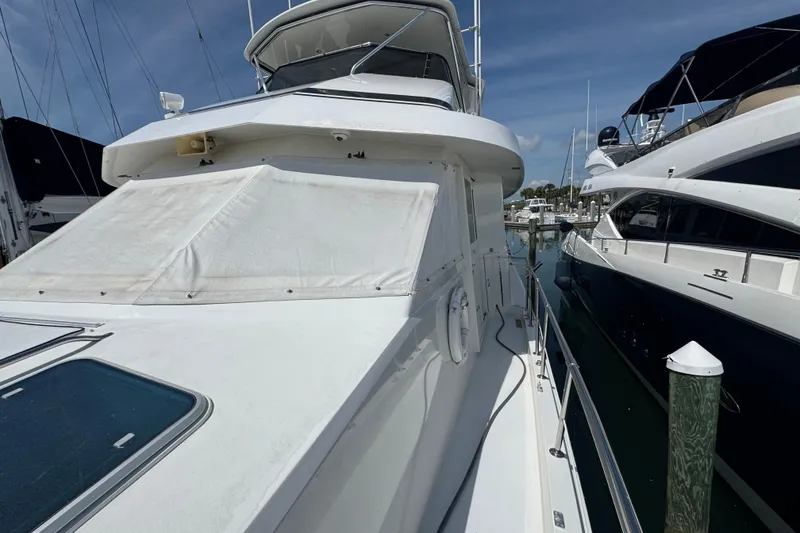Slide: The Image of 1995 Hatteras 74 Cockpit Motor Yacht docked at marina, side view. - 8