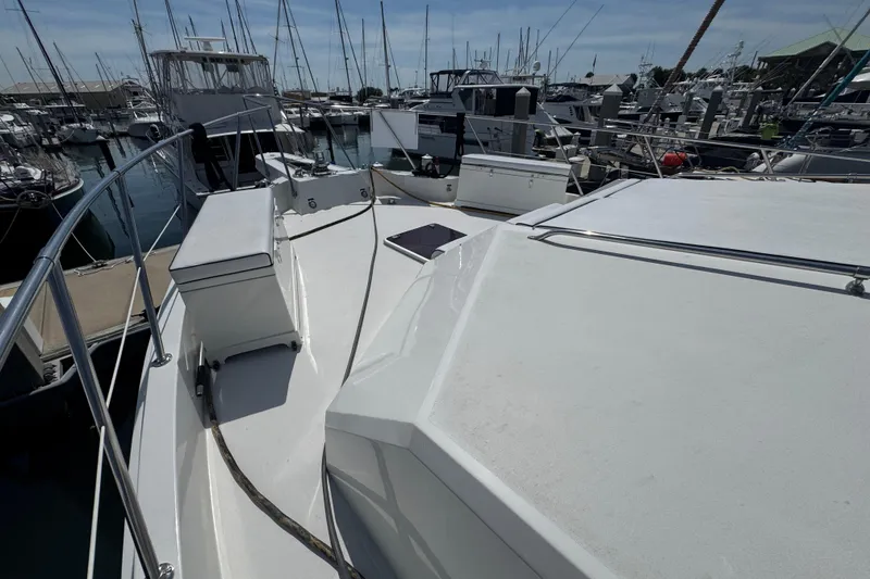 Slide: The Image of 1995 Hatteras 74 Cockpit Motor Yacht docked at marina, surrounded by other boats. - 9
