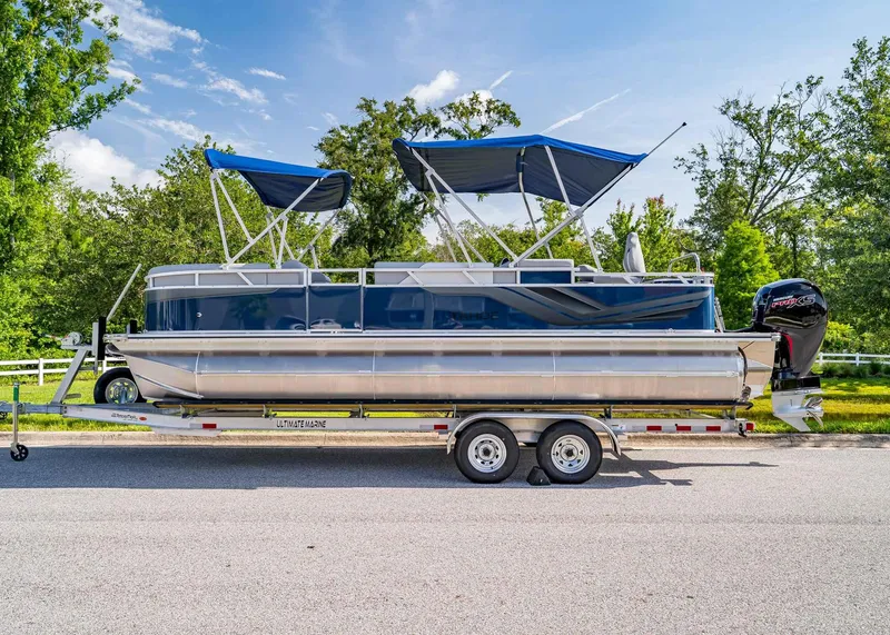 Slide: The Image of 2025 Tahoe SPORTS 85 REAR FISH boat on trailer, parked on a sunny day. - 2