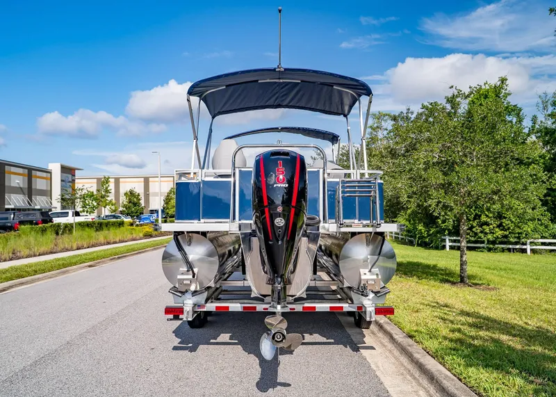 Slide: The Image of 2025 Tahoe SPORTS 85 REAR FISH boat on trailer, parked on a sunny street. - 4