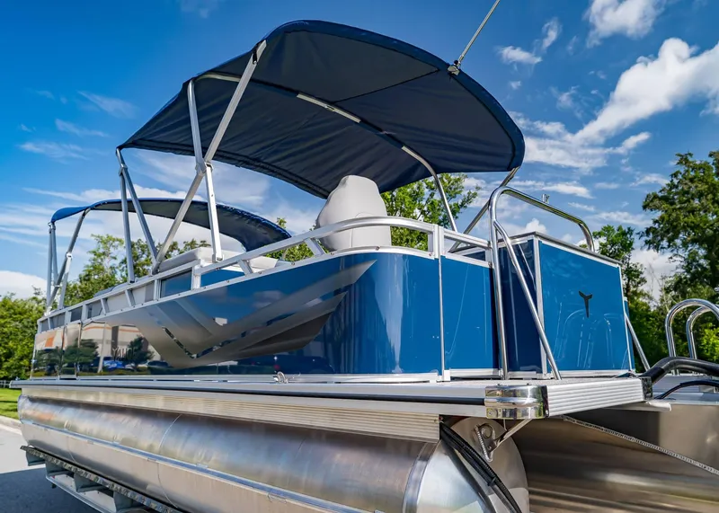 Slide: The Image of 2025 Tahoe SPORTS 85 REAR FISH pontoon boat with blue canopy under clear sky. - 5