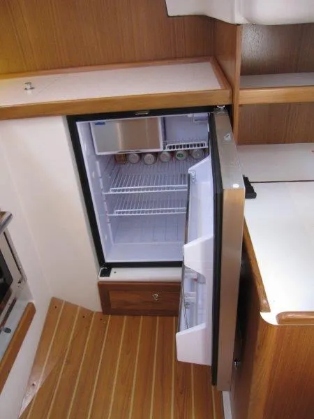 Slide: The Image of 2024 Catalina 385 yacht interior with open fridge in wooden kitchen. - 12