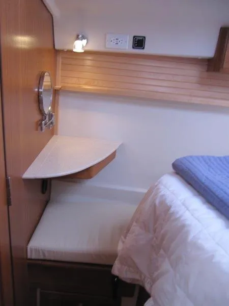 Slide: The Image of 2024 Catalina 385 yacht interior with cozy bed and wooden accents. - 22