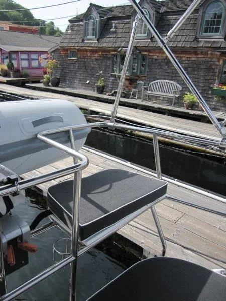 Slide: The Image of 2024 Catalina 385 yacht with seating, docked near rustic waterfront buildings. - 40