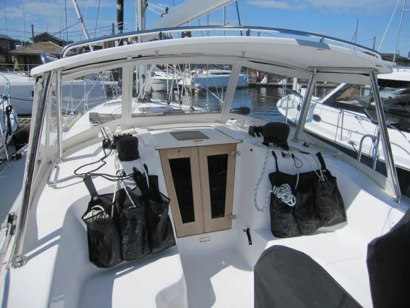 Slide: The Image of 2024 Catalina 385 sailboat cockpit with storage bags and wooden hatch, docked at marina. - 46