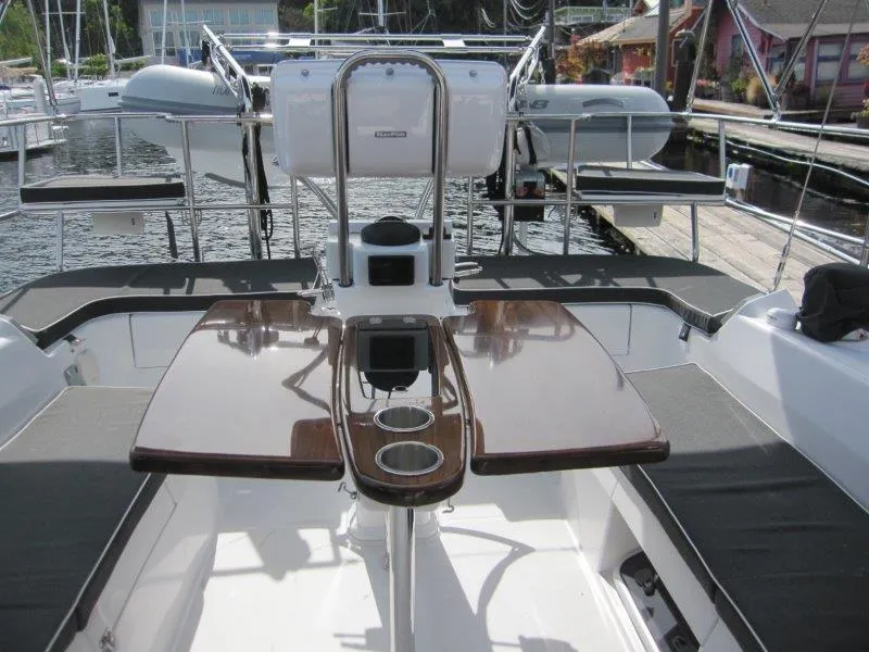 Slide: The Image of 2024 Catalina 385 yacht cockpit with polished table and seating, docked at marina. - 47