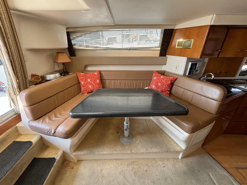 Slide: The Image of Interior of 2002 Carver 350 Mariner yacht with cozy dining area and leather seating. - 10