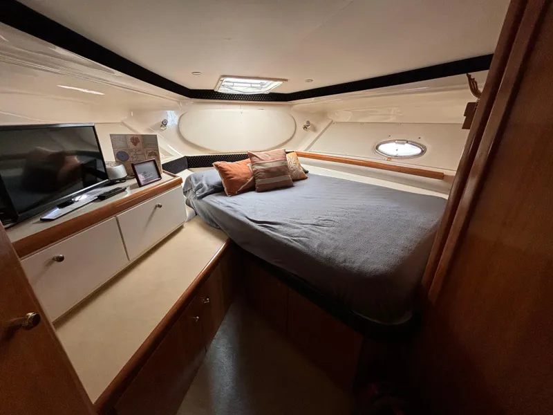 Slide: The Image of Cozy cabin interior of 2002 Carver 350 Mariner with bed, TV, and porthole. - 16