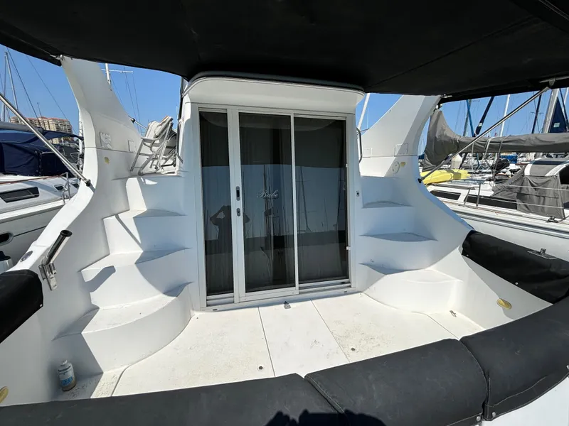 Slide: The Image of 2002 Carver 350 Mariner yacht deck with seating and sliding door, docked at marina. - 2