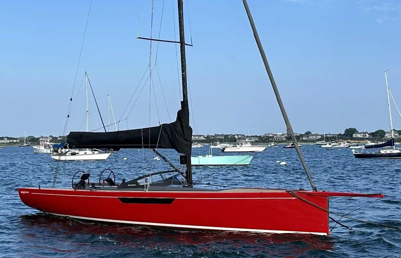 Slide: The Image of Red 2023 Saffier 33 Life sailboat on calm water, surrounded by other boats. - 9