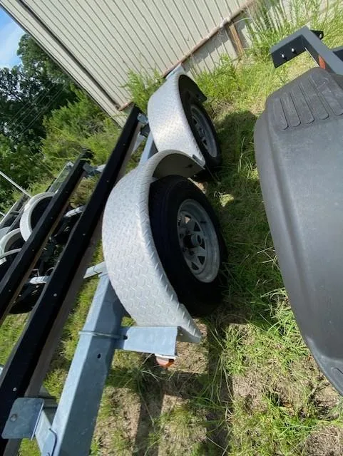 Slide: The Image of Trailer for 2006 Scout 222 Sportfish boat, parked on grass near a building. - 11