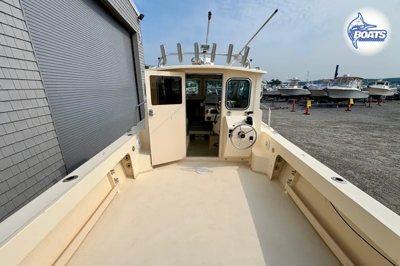 Slide: The Image of 2011 Parker Sport Cabin SL boat docked near a storage facility. - 10