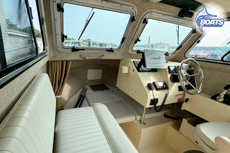 Slide: The Image of 2011 Parker Sport Cabin SL interior with Garmin navigation, steering wheel, and seating. - 11