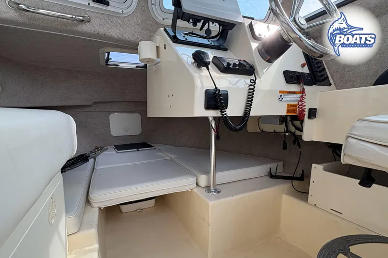 Slide: The Image of Interior of a 2011 Parker Sport Cabin SL boat, featuring steering and seating area. - 16