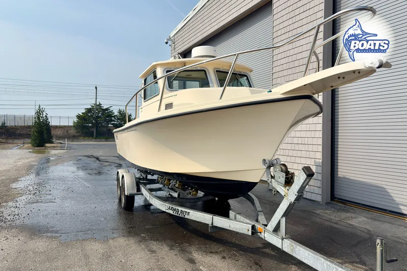 Slide: The Image of 2011 Parker Sport Cabin SL boat on trailer near building. - 2