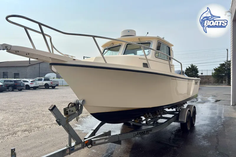 Slide: The Image of 2011 Parker Sport Cabin SL boat on trailer in parking lot. - 4