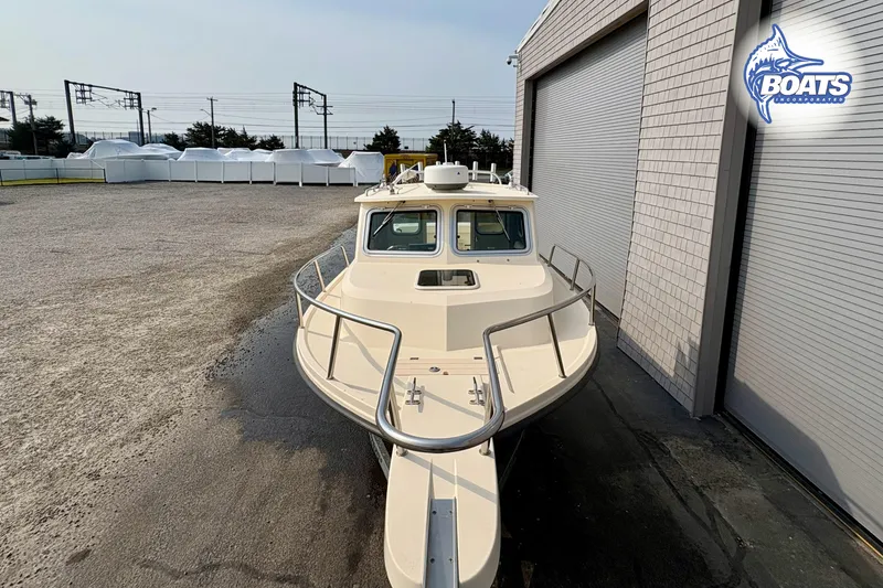 Slide: The Image of 2011 Parker Sport Cabin SL boat parked near a building, showcasing its sleek design. - 5