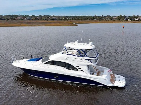 Slide: The Image of 2006 Sea Ray 580 Sedan Bridge yacht on calm water, showcasing sleek design and spacious deck. - 0