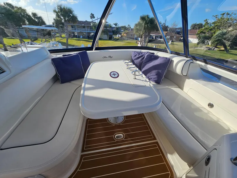 Slide: The Image of 2006 Sea Ray 580 Sedan Bridge interior with cushioned seating and table, surrounded by windows. - 16