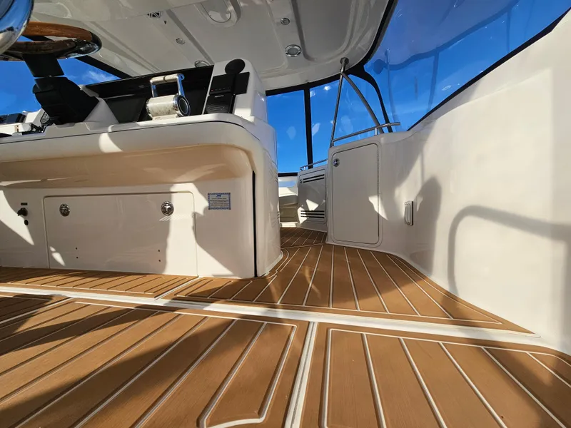 Slide: The Image of 2006 Sea Ray 580 Sedan Bridge interior with wooden flooring and modern helm controls. - 18