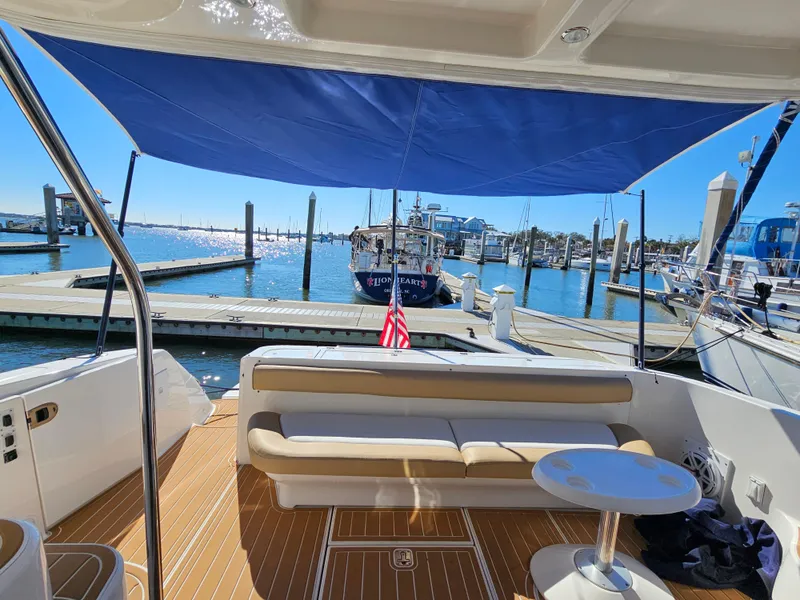 Slide: The Image of 2006 Sea Ray 580 Sedan Bridge yacht interior with seating, table, and marina view. - 19