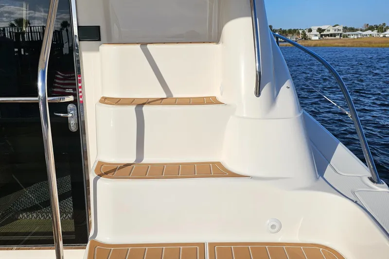 Slide: The Image of Stairs on a 2006 Sea Ray 580 Sedan Bridge yacht, overlooking water and distant houses. - 28