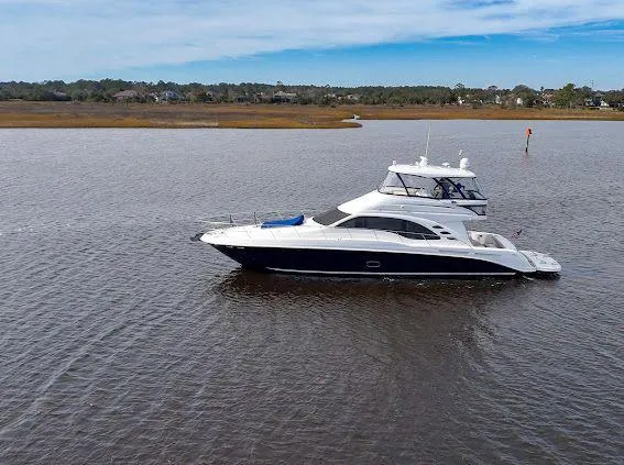 Slide: The Image of 2006 Sea Ray 580 Sedan Bridge yacht cruising on calm waters under a clear sky. - 4