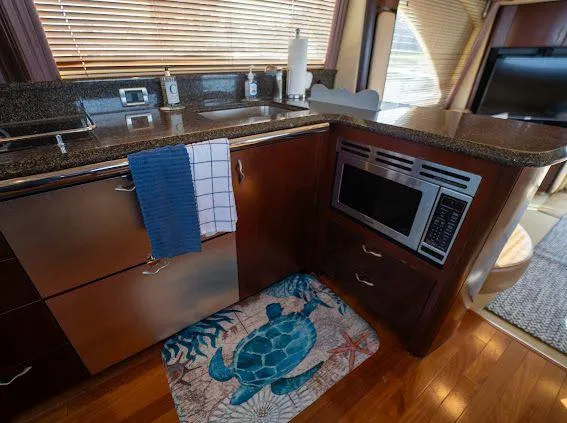 Slide: The Image of Interior of 2006 Sea Ray 580 Sedan Bridge kitchen with microwave and turtle-themed rug. - 45