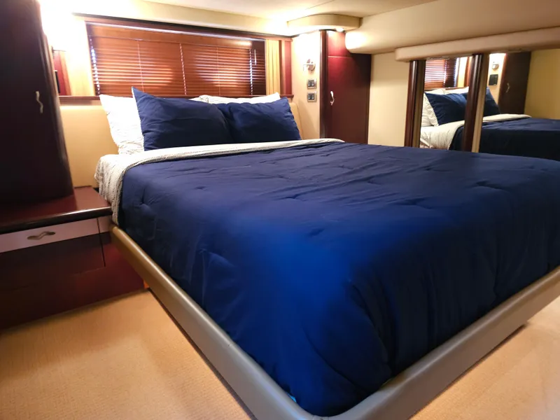 Slide: The Image of Luxurious bedroom interior of 2006 Sea Ray 580 Sedan Bridge yacht with blue bedding. - 46