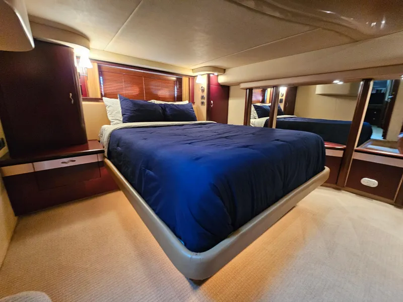 Slide: The Image of Luxurious bedroom interior of 2006 Sea Ray 580 Sedan Bridge yacht with blue bedding. - 47