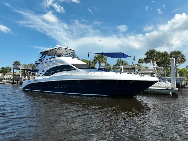 Slide: The Image of 2006 Sea Ray 580 Sedan Bridge yacht docked on a sunny day with blue skies. - 6