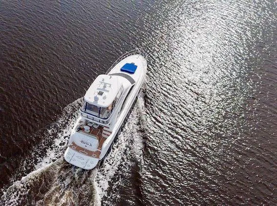 Slide: The Image of 2006 Sea Ray 580 Sedan Bridge yacht cruising on sunlit water. - 9